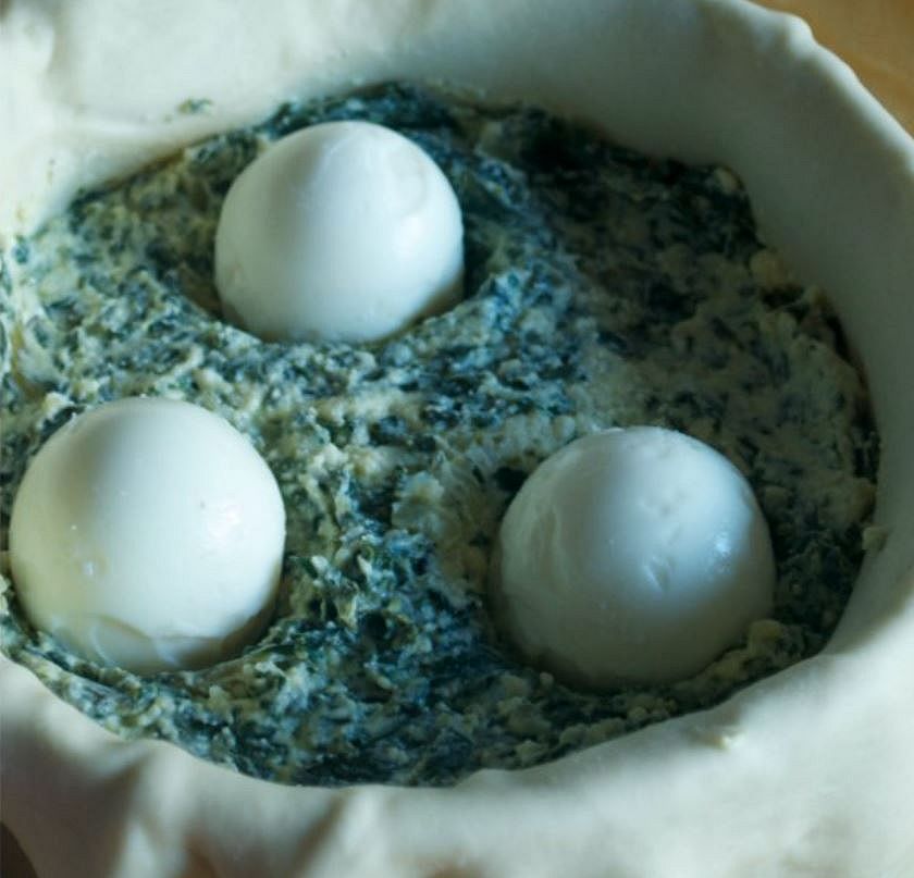 uova messe nelle conche del ripieno della torta pasqualina