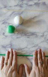 mani che formano un serpentello di pasta di zucchero verde