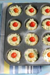 muffin inseriti nella teglia apposita con mezzo pomodorino sulla superficie