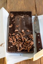 riccioli di cioccolato su una tavoletta fondente e un coltello in parte