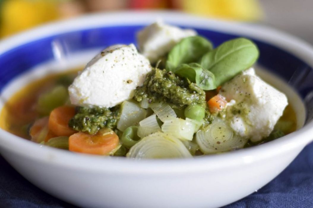 zuppa di verdure con quenelle di formaggio e foglie di basilico