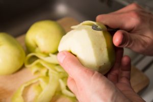 mano che sbucciano una mela
