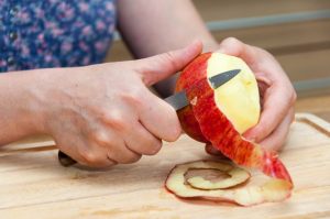 mani che sbucciano una mela