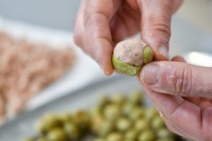 mani che riempiono le olive