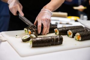 maki sushi che viene tagliato su tagliere