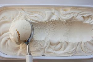 pallina di gelato alla vaniglia presa dalla vaschetta
