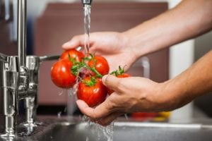 pomodori tondi sotto l'acqua di rubinetto
